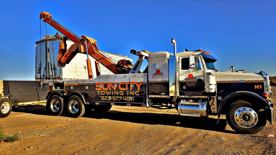 A red and silver towing truck with an extended boom, branded