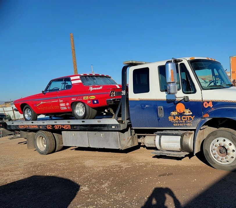 sun city tow truck towing a red car