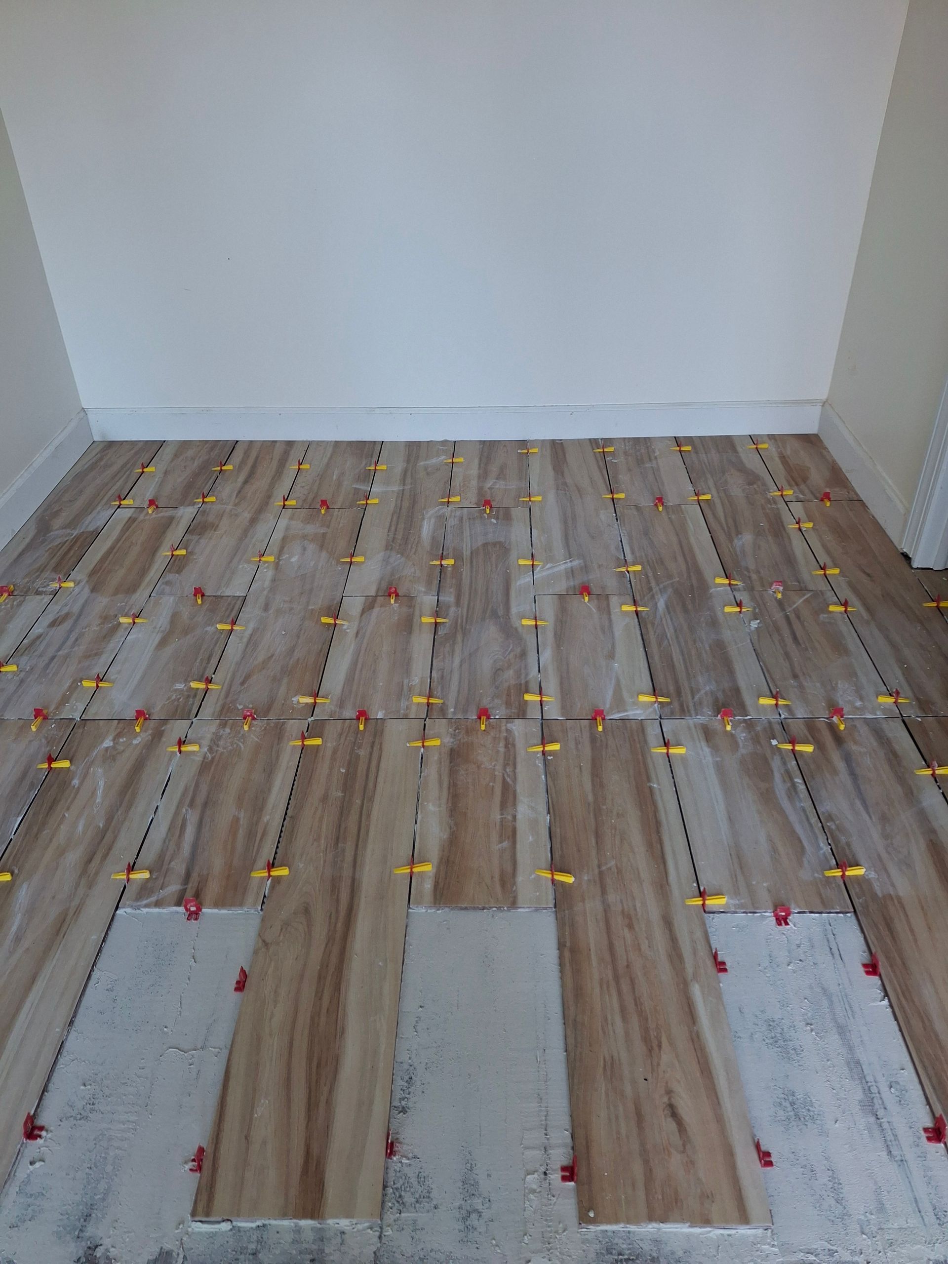 A room with a wooden floor and a white wall.