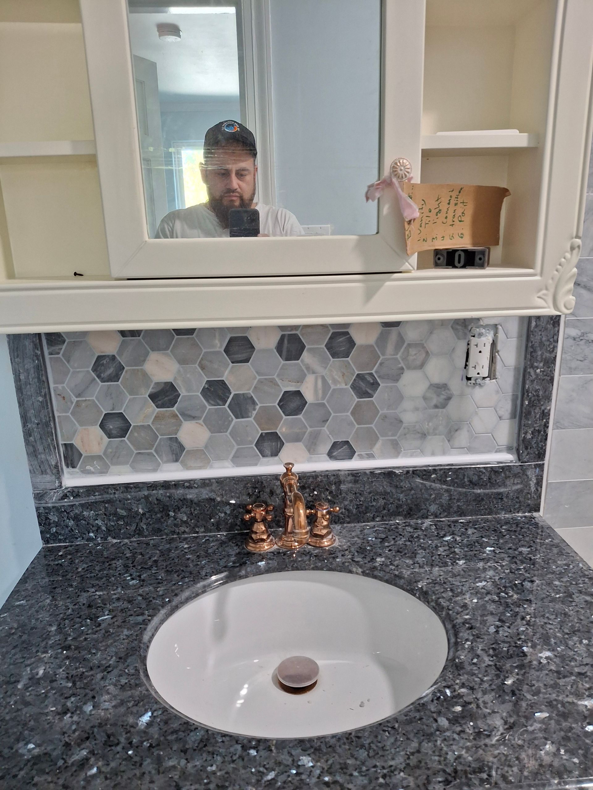 A man is taking a picture of himself in a bathroom mirror.