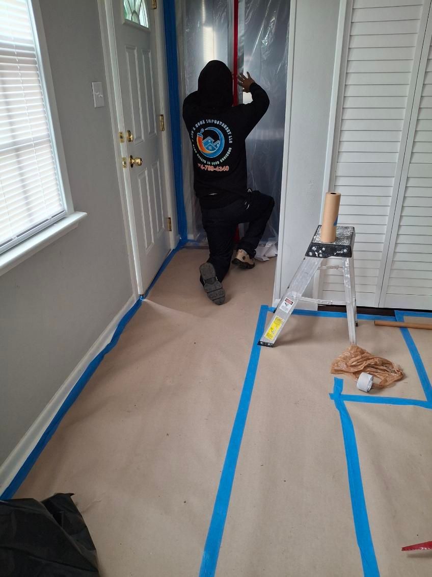 A man is standing in a hallway with blue tape on the floor.