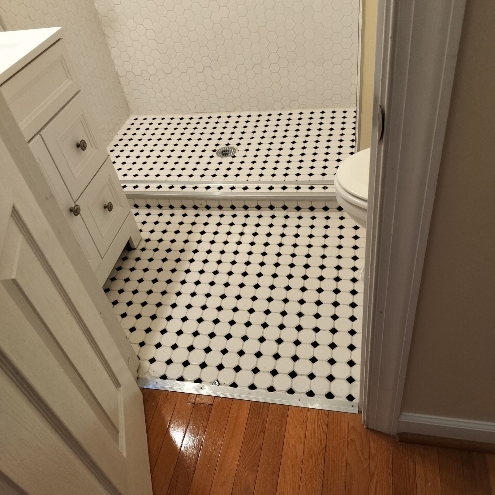 A bathroom with a black and white tile floor