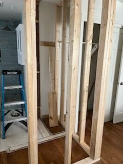 A wooden frame is being built in a room with a ladder.
