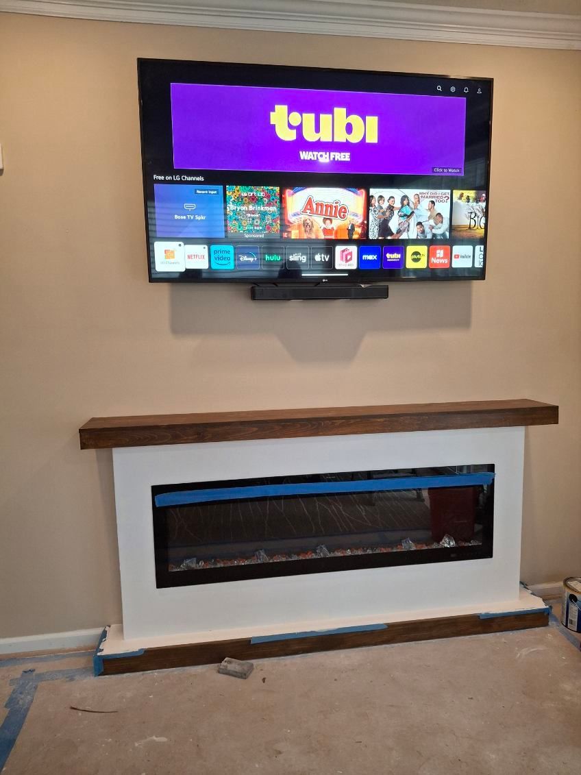 A fireplace with a flat screen tv above it that says tubi