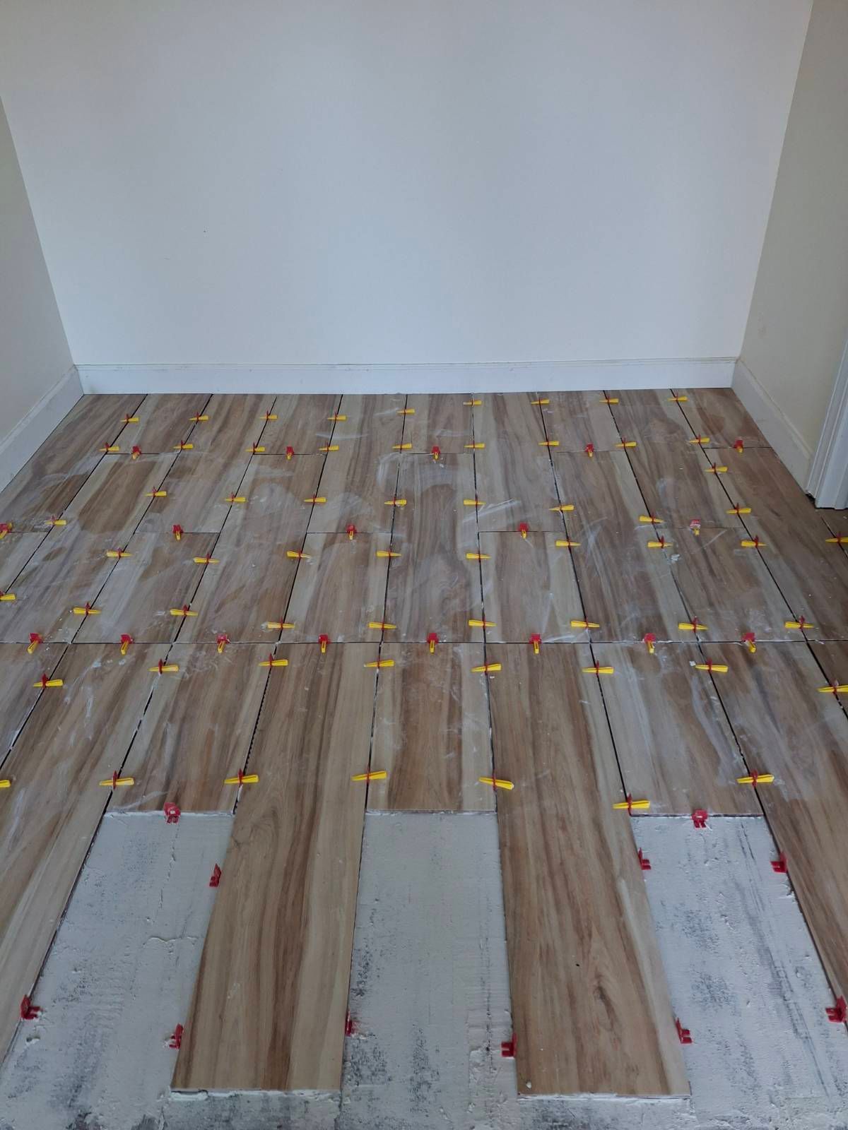 A room with a wooden floor and a white wall.