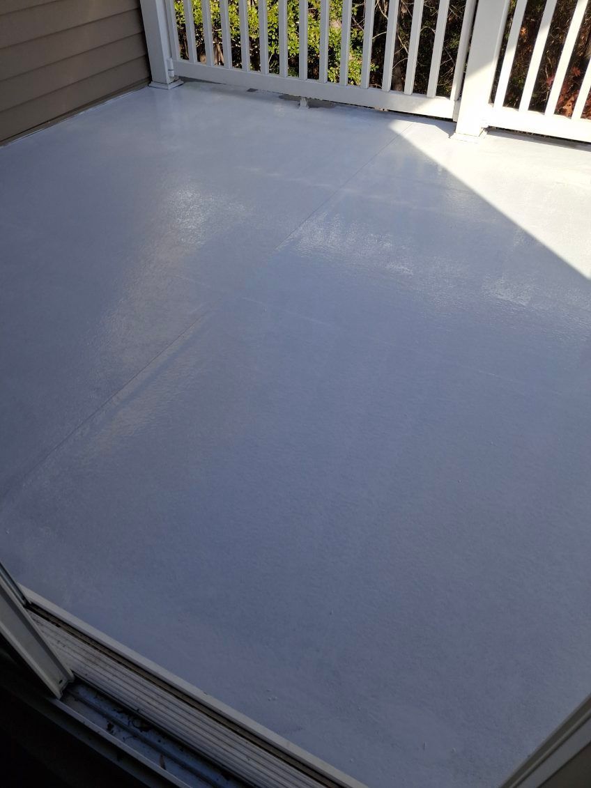 A white deck with a white railing and a white fence.