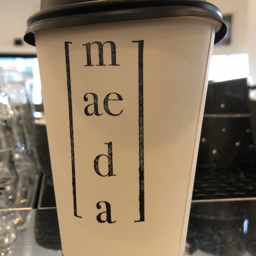 A cup that says ' m ae d a ' on it