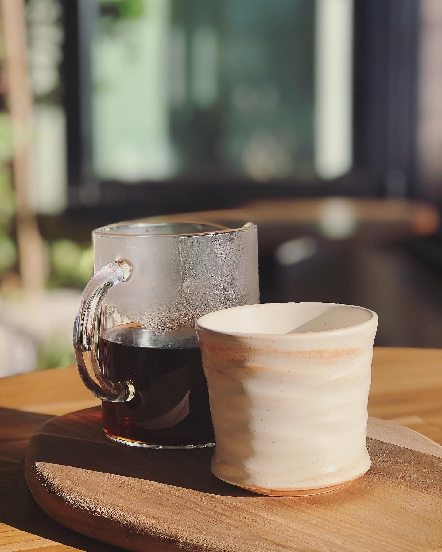 Two cups of coffee are sitting on a wooden table.