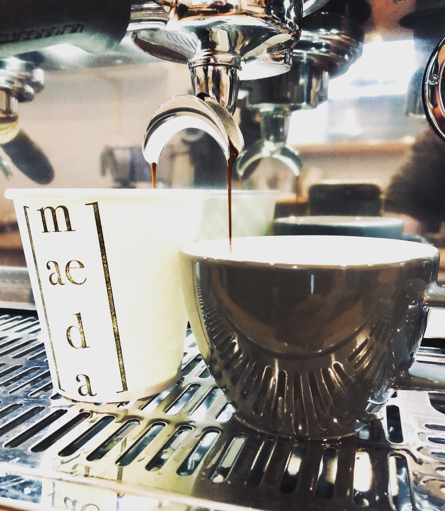 A cup of coffee is being poured into a cup that says m ac d a