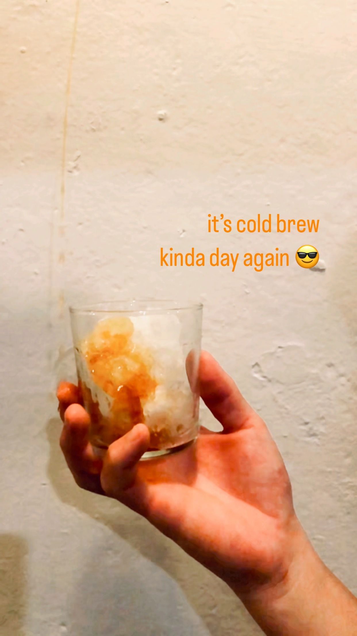 A person is holding a glass of ice cream in their hand.