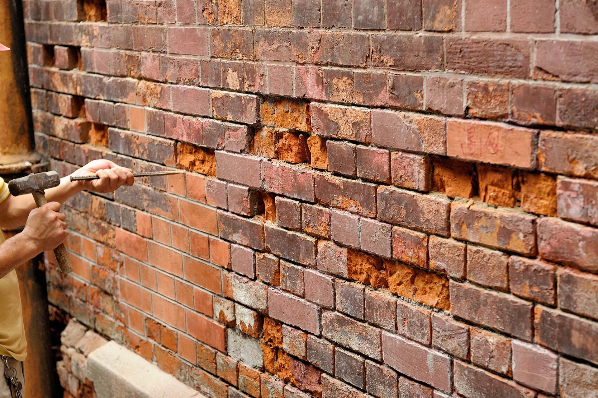 A man is repairing a brick wall.