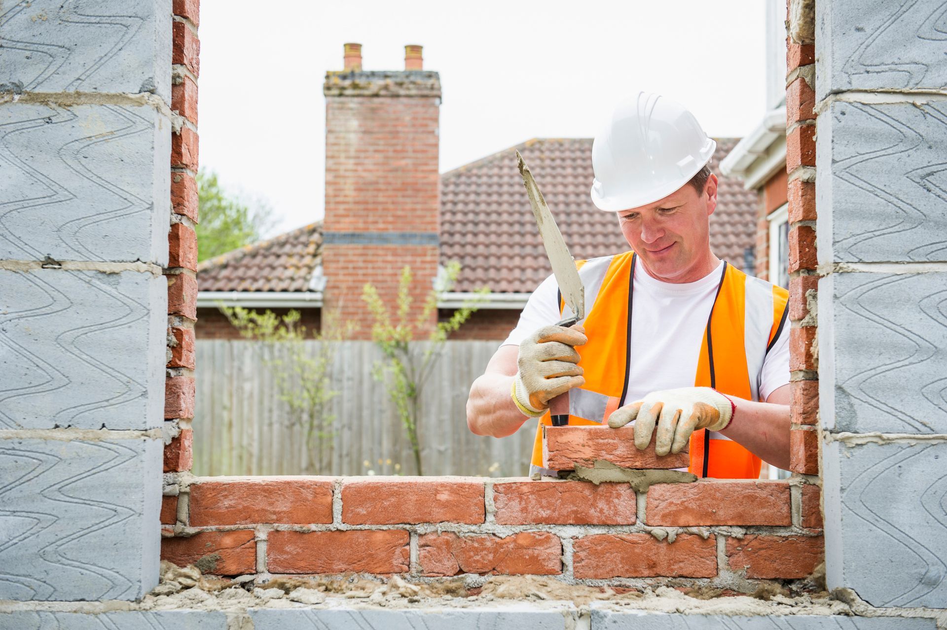 Construction worker laying bricks with mortar Construction worker laying bricks with mortar
