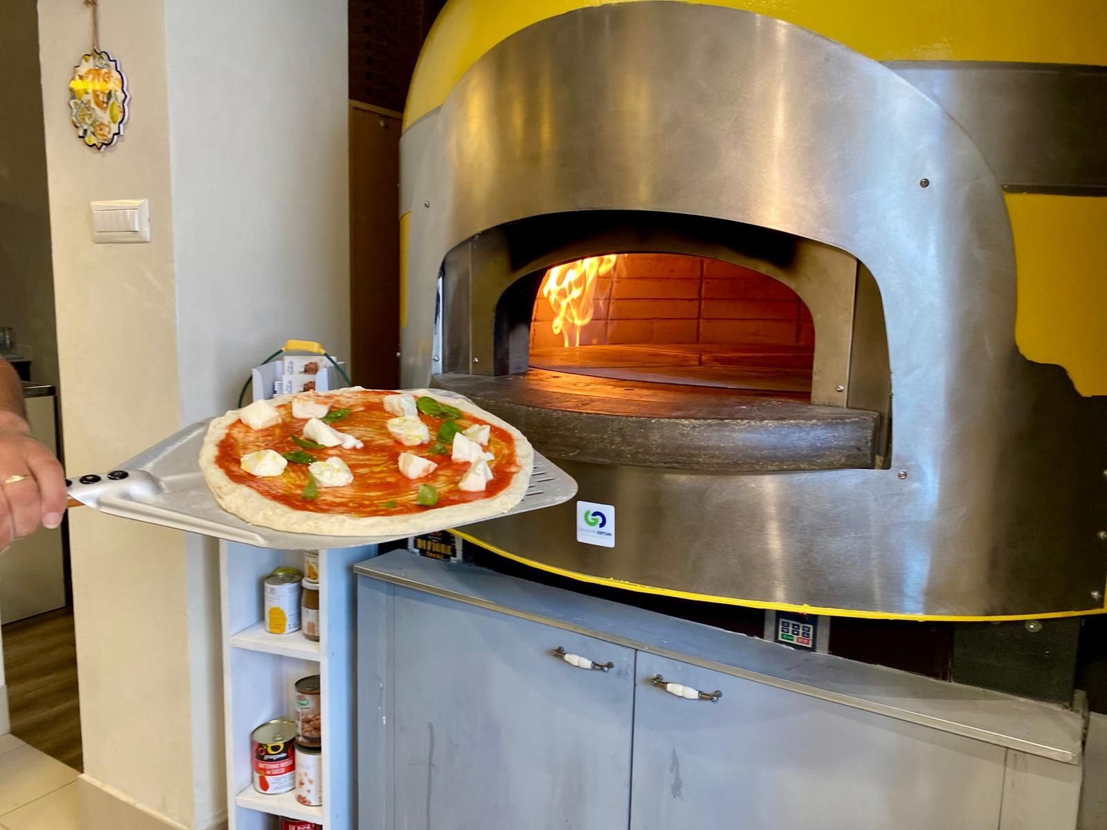 Una pizza viene tolta dal forno