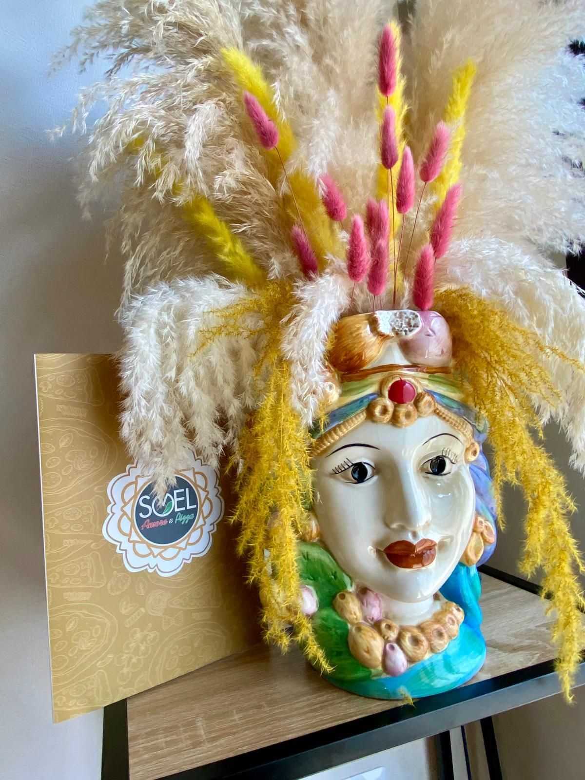 Un vaso con il volto di una donna è appoggiato su un tavolo.