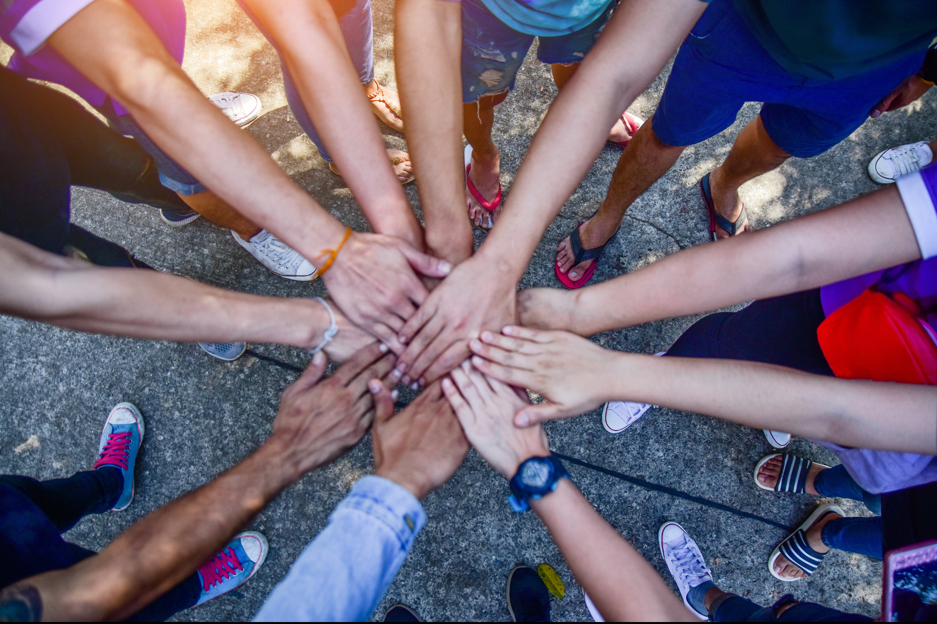 people standing in a circle with one hand each in the middle