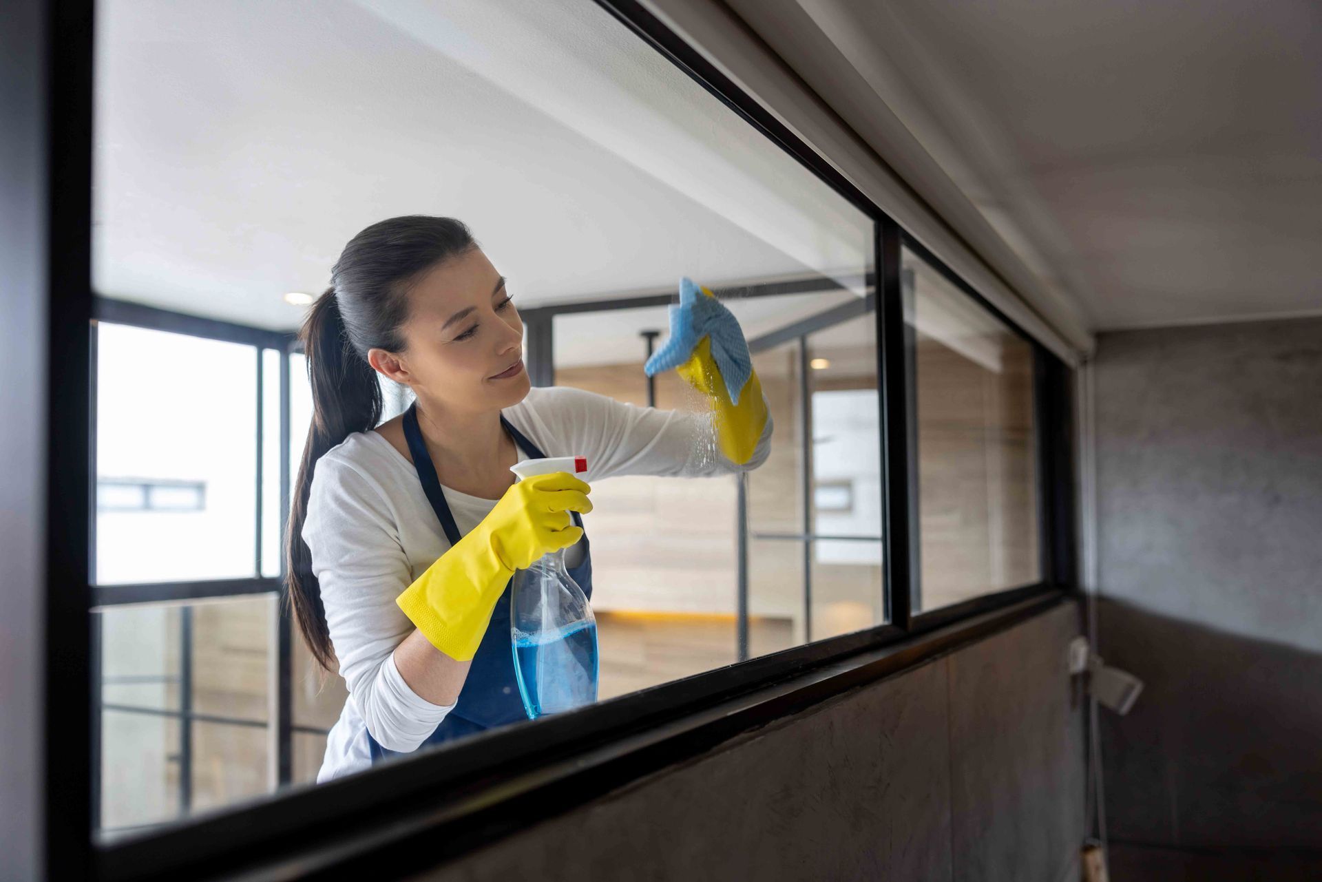 Professional Cleaner Cleaning A Glass Window At An Apartment — Appleton, WI — Confident Cleaners LLC