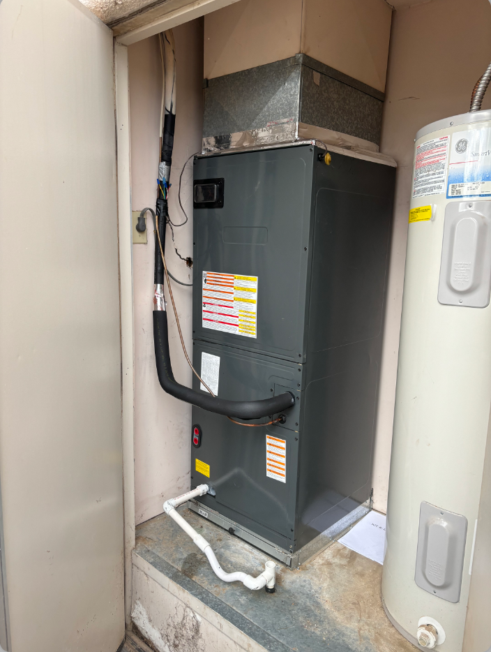 A man is standing in front of a truck holding a red backpack.