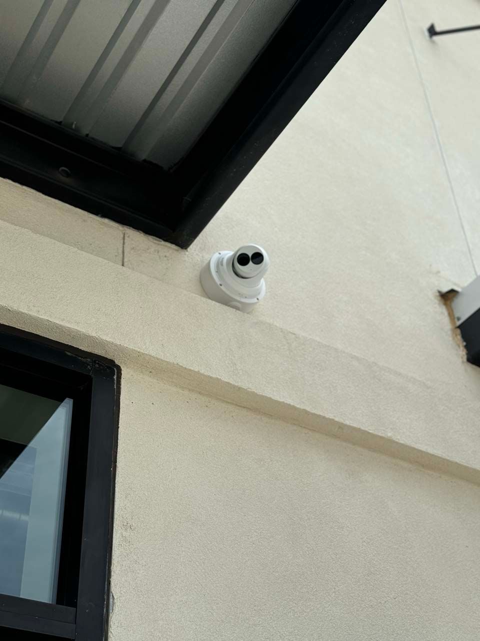 A security camera is mounted on the side of a building