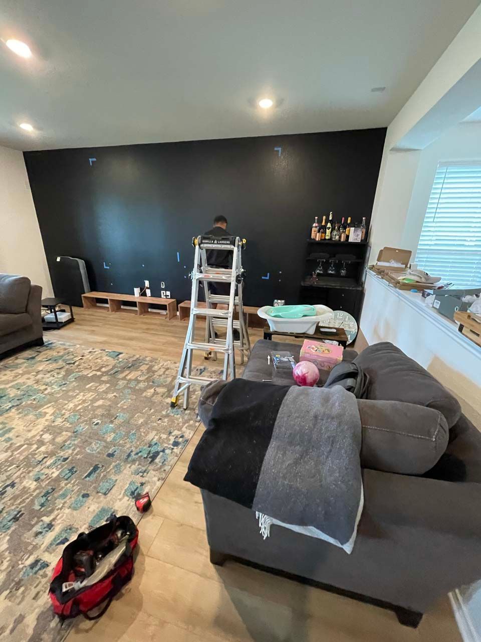 A living room with a couch and a ladder in it.