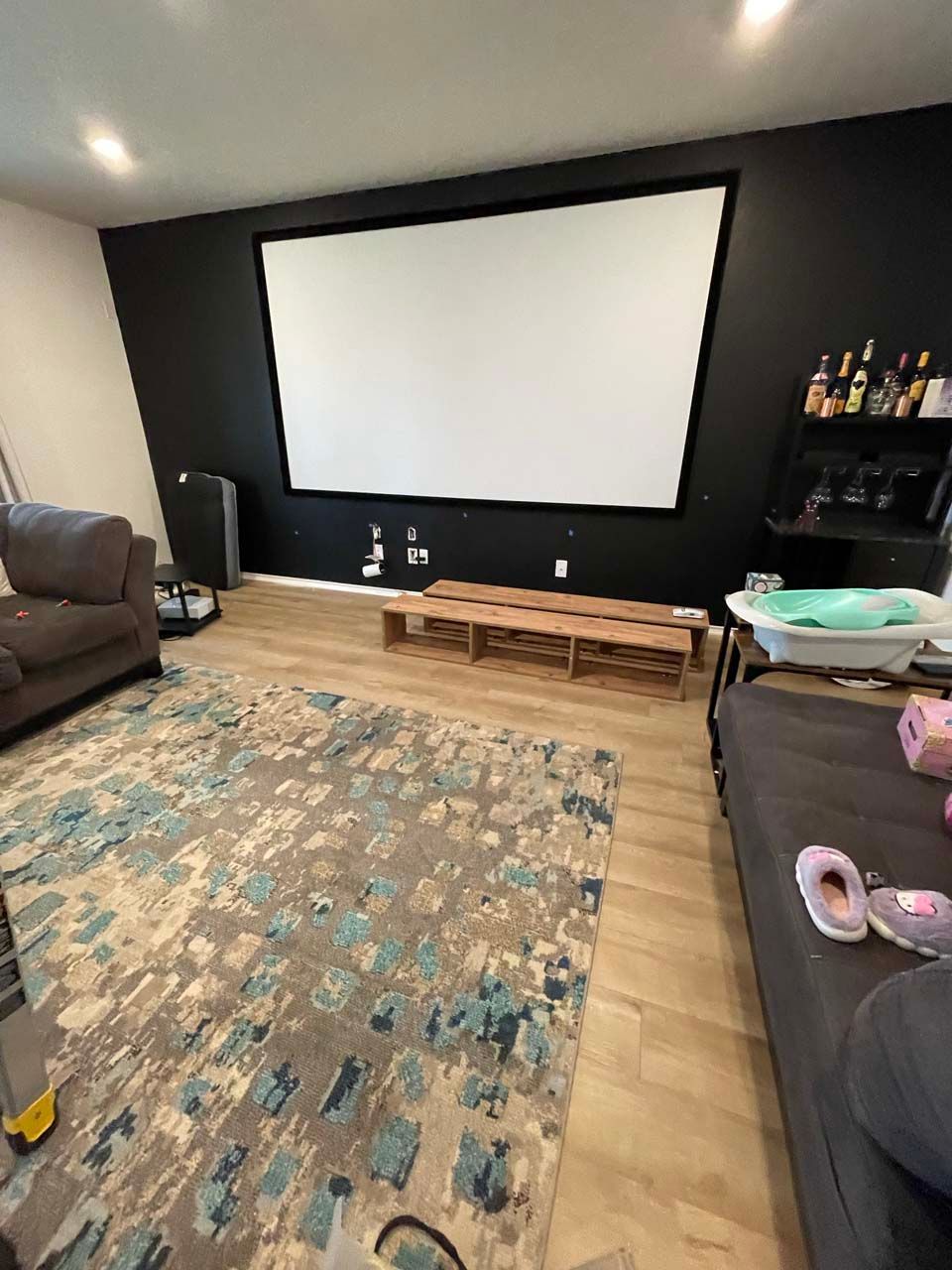 A living room with a projector screen and a couch.