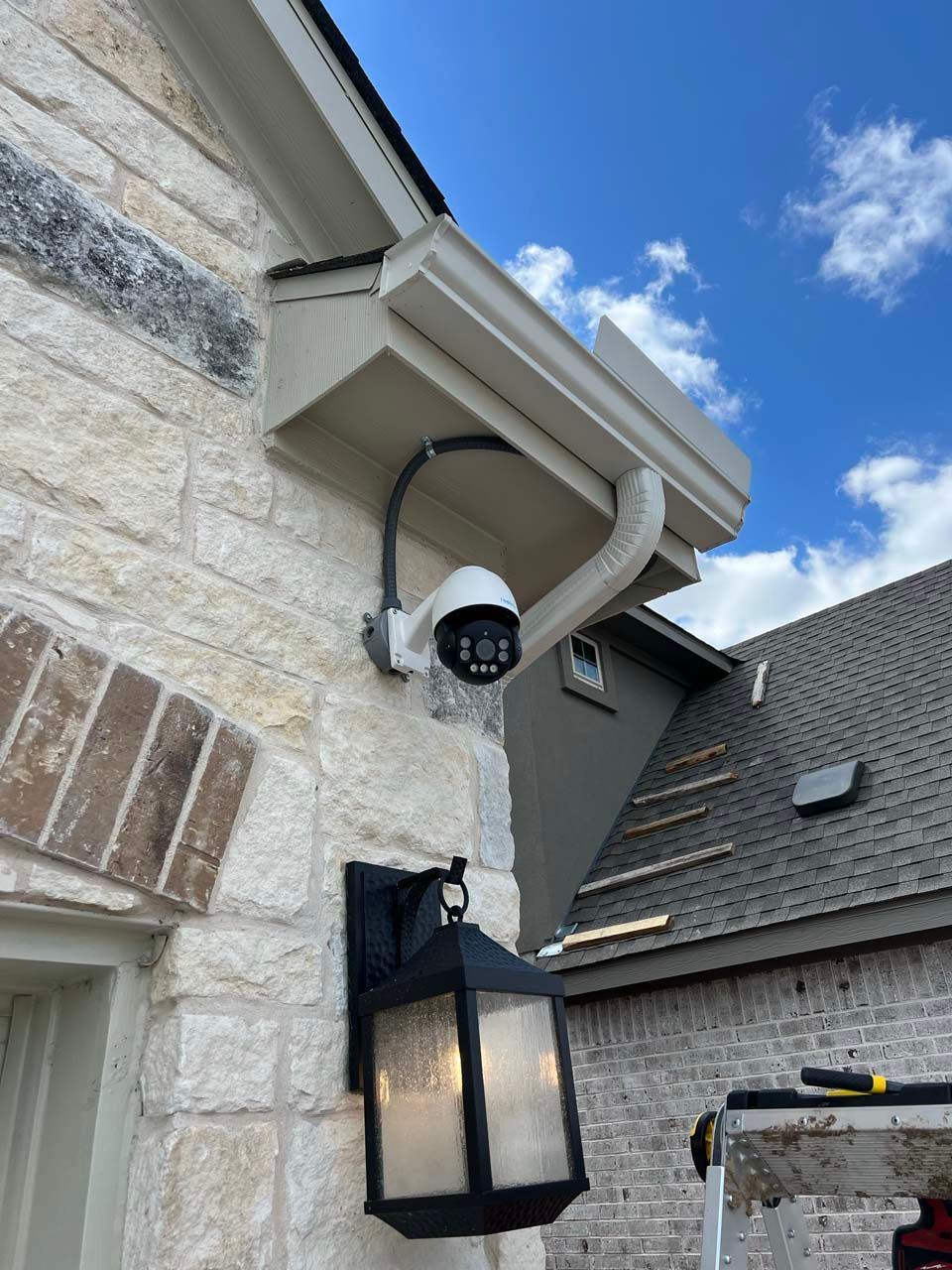 A security camera is mounted on the side of a brick building.