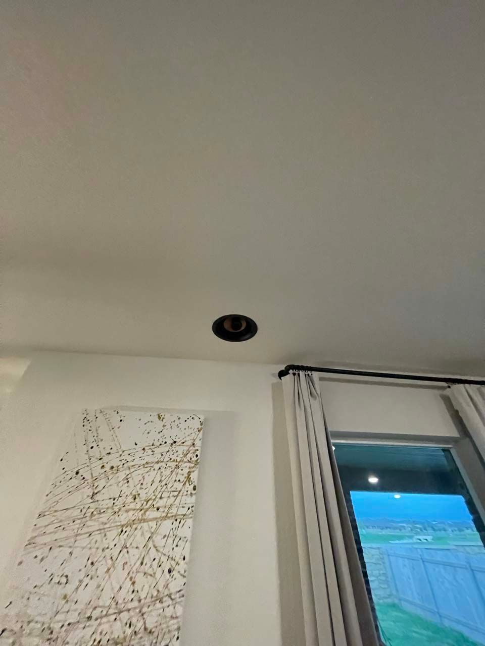 A room with a ceiling light and a window.