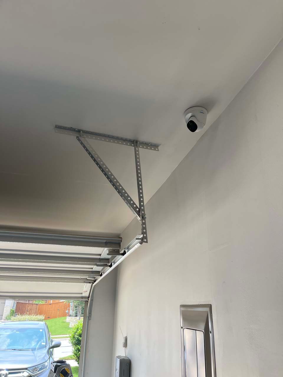 A car is parked in a garage with the door open.