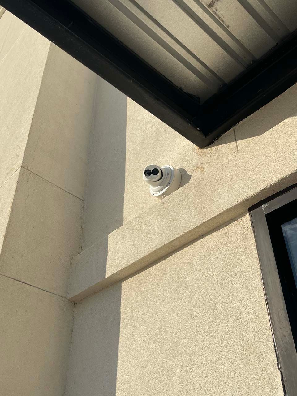 A security camera is mounted on the side of a building.