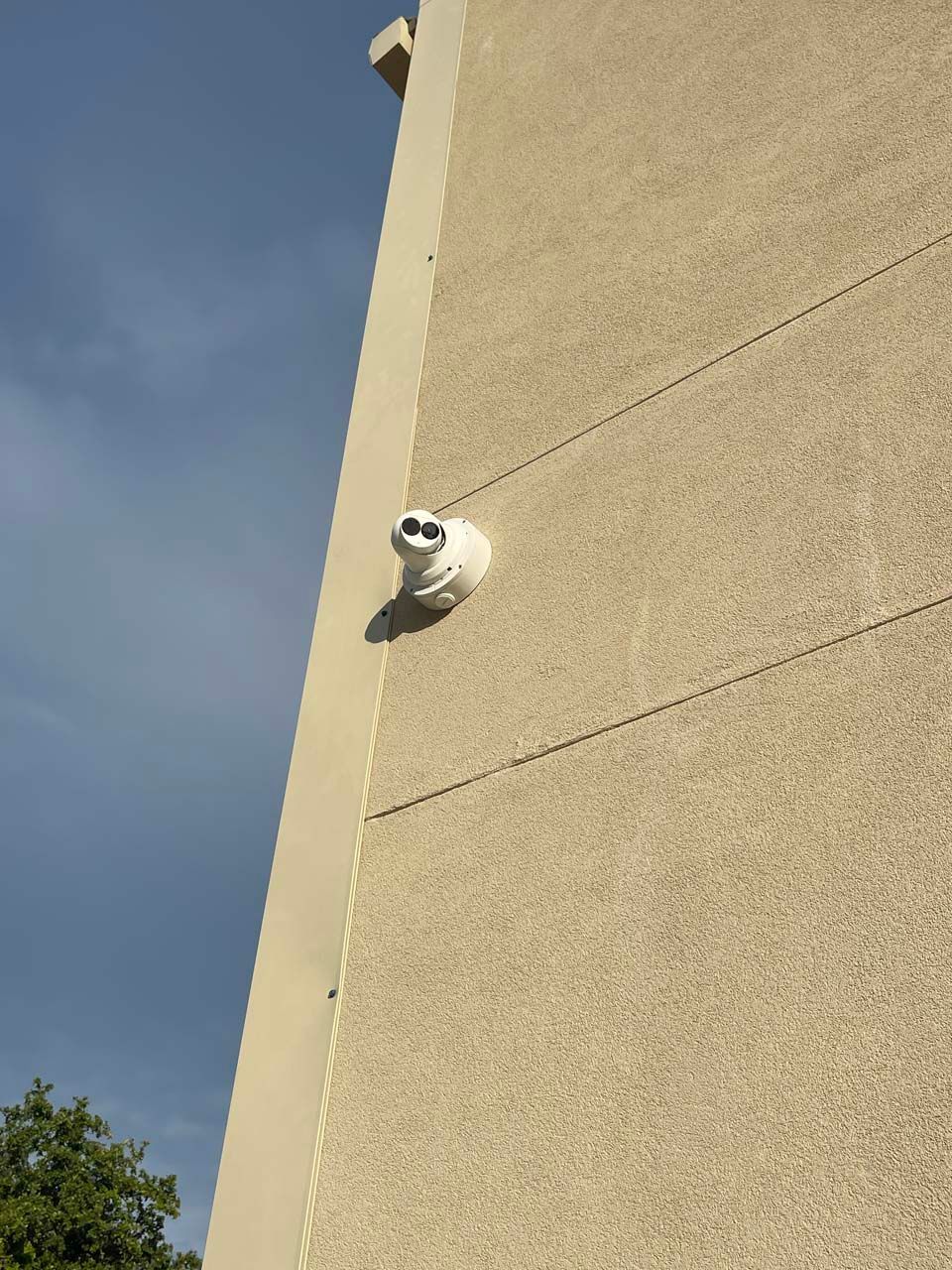 A security camera is mounted on the side of a building.