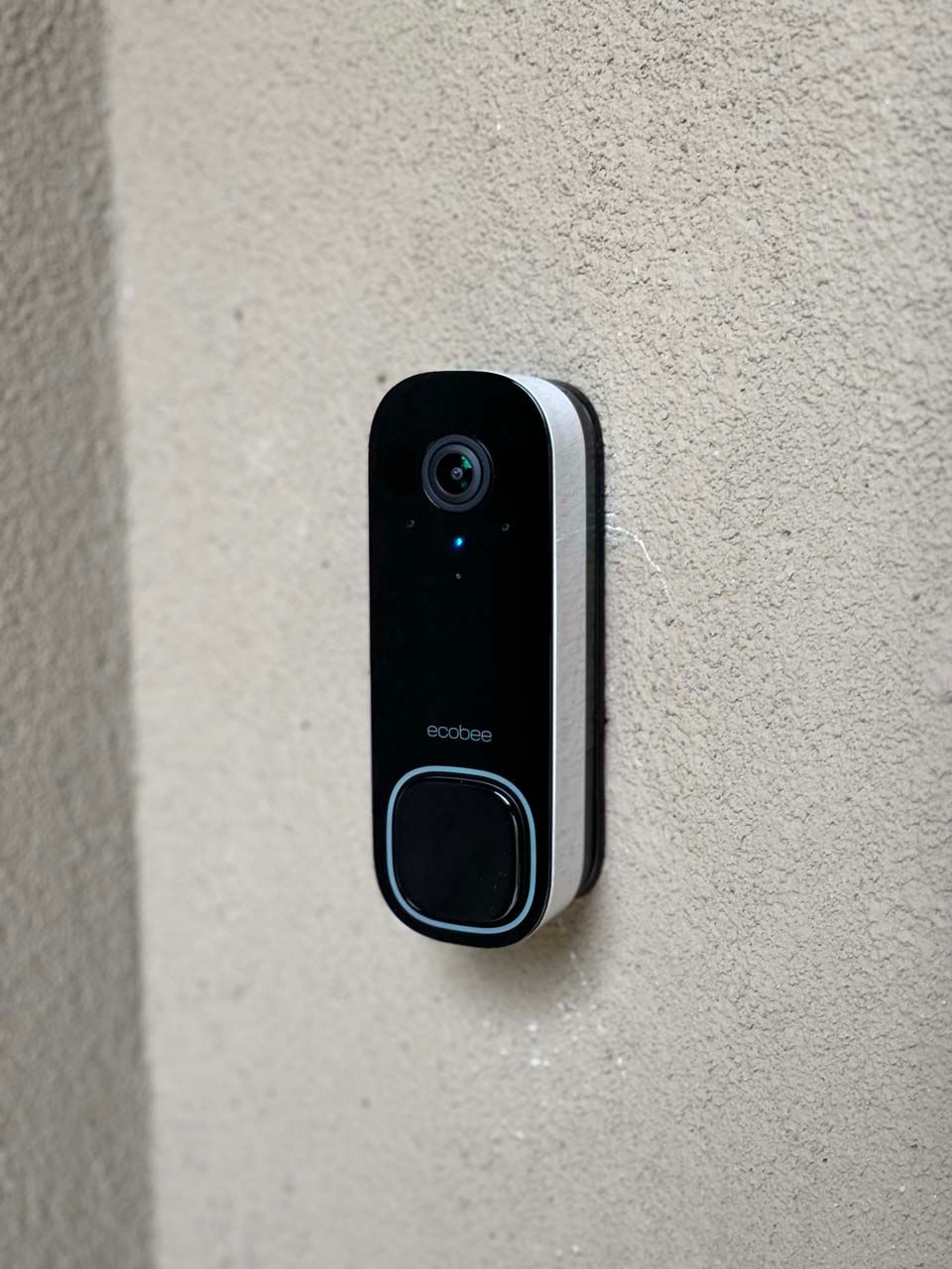 A doorbell is mounted on a white wall.