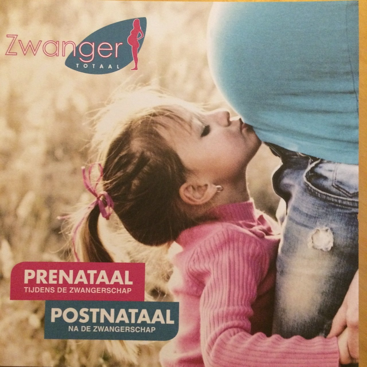 Jong meisje kust de zwangere buik van een persoon