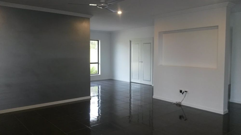 An Empty Living Room with A Black Floor and A Ceiling Fan — A Brush With Colour in Wondunna, QLD