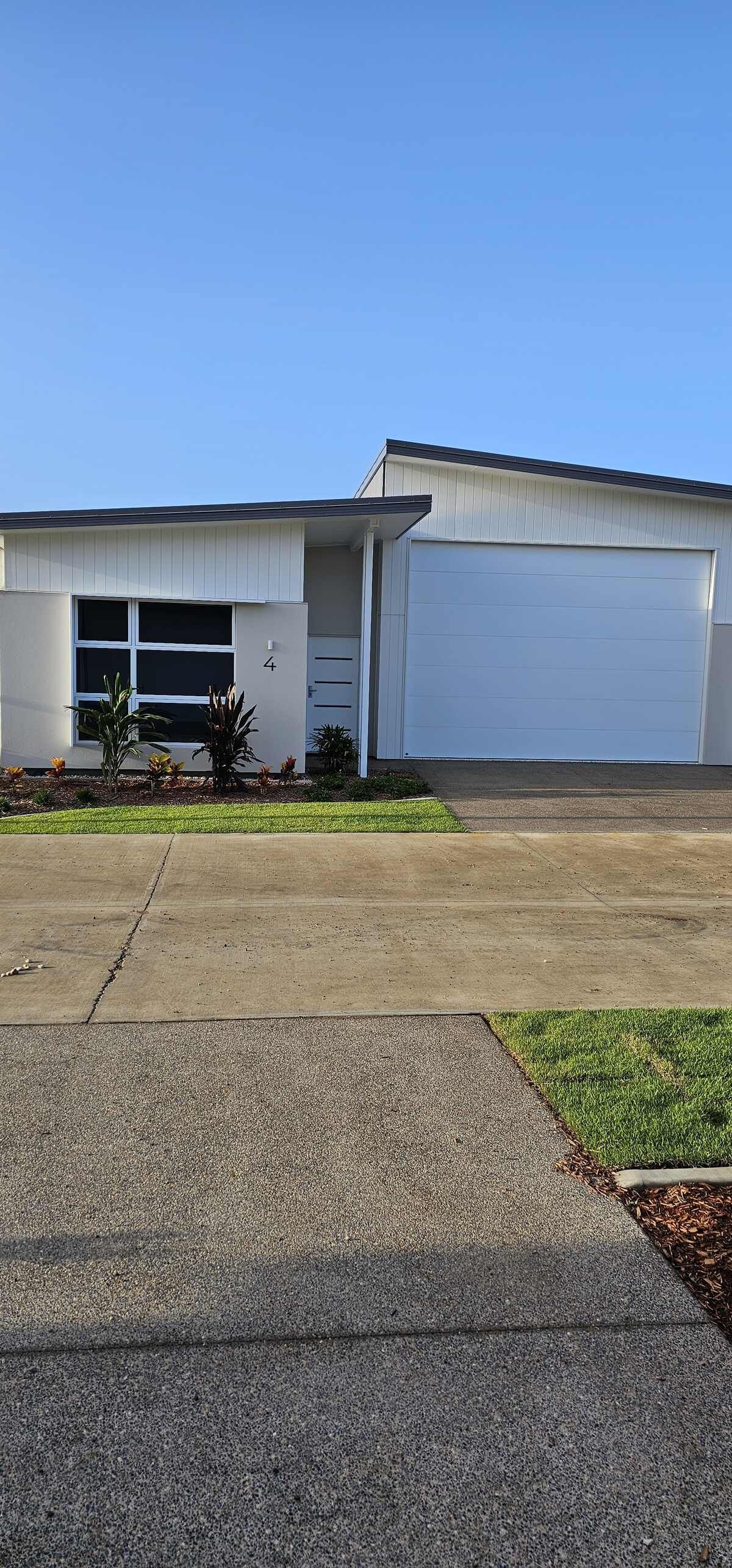 A Man Is Standing on A Scaffolding Painting a House — A Brush With Colour in Torquay, QLD