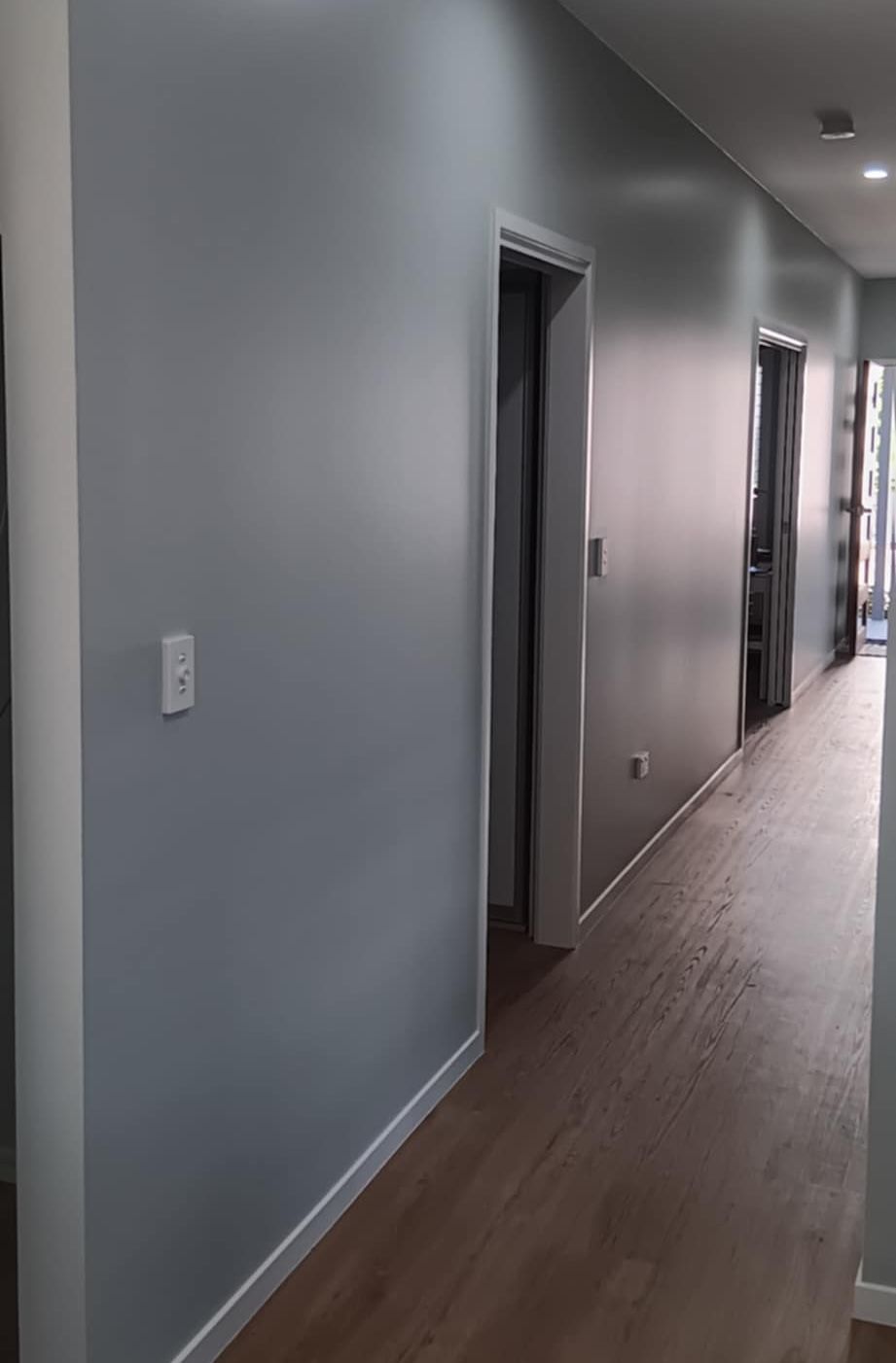 A Person Is Painting a Wall with A Paint Roller — A Brush With Colour in Urangan, QLD