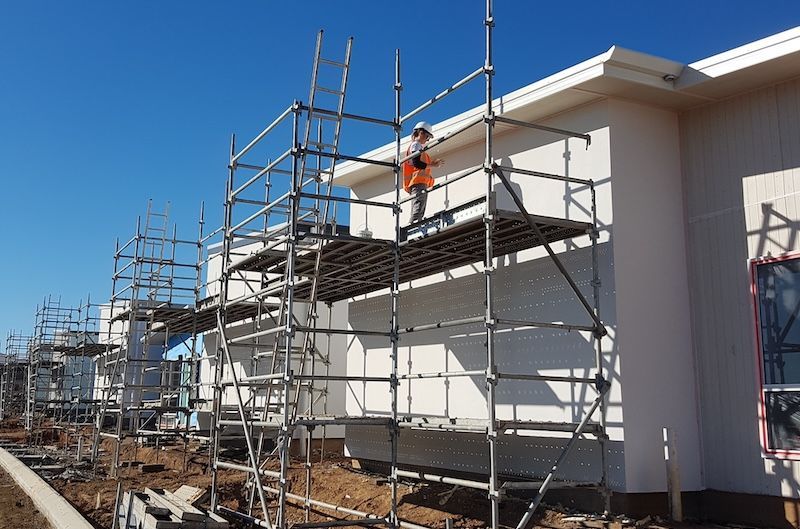 A Man Is Painting a White Railing on A Balcony — A Brush With Colour in Pialba, QLD
