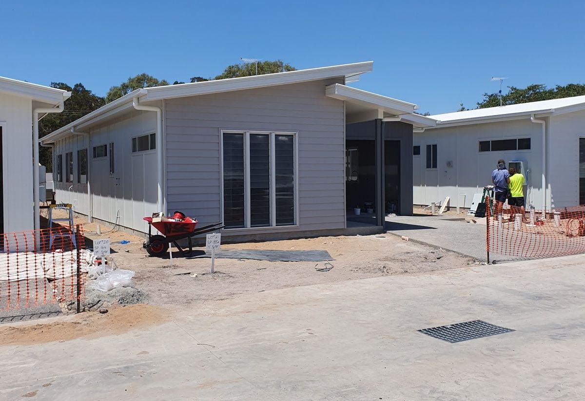 A Man in A Protective Suit Is Painting a Wall on A Lift — A Brush With Colour in Eli Waters, QLD