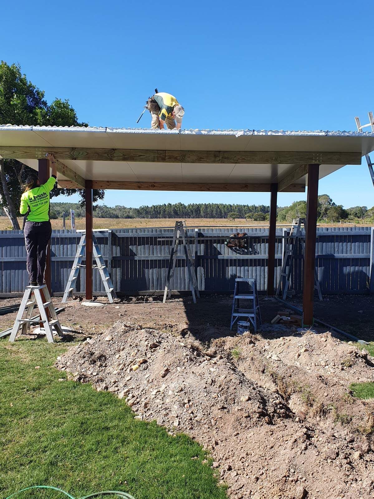 A Man Is Working on The Roof of A Building — A Brush With Colour in Pialba, QLD