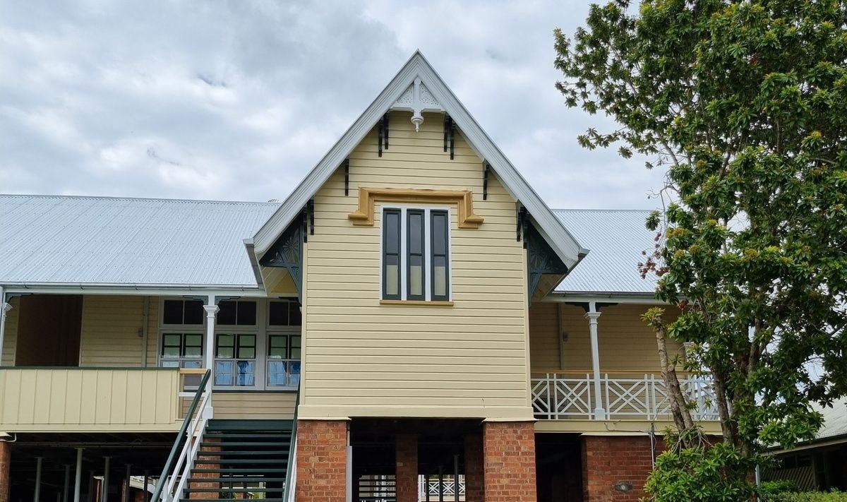 A Man Is Working on The Roof of A Building — A Brush With Colour in Torquay, QLD