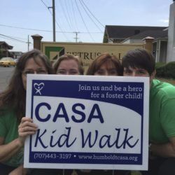 A group of people are holding a sign that says casa kid walk.