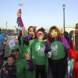 A group of people wearing green and purple superhero costumes