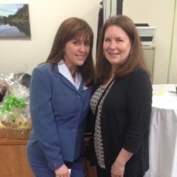 Two women are standing next to each other and smiling for the camera