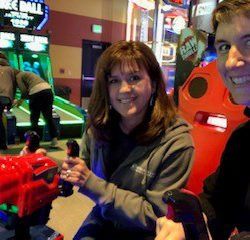 A man and a woman are sitting next to each other in an arcade.