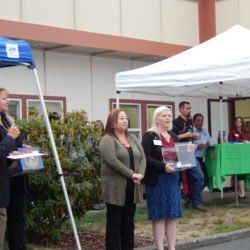 A group of people are standing under a tent in front of a building.