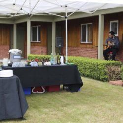 A man is sitting on a porch playing a guitar.