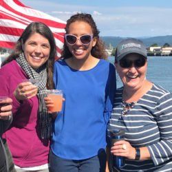 Three women standing next to each other holding drinks
