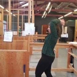 A woman is standing in a room with her arms outstretched.