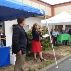 A woman in a red dress is speaking into a microphone