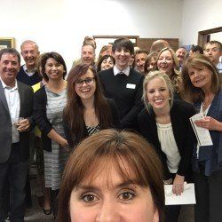 A woman is taking a selfie with a group of people.