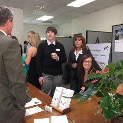 A group of people are standing around a table in a room.