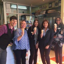 A group of people holding ice cream cones in a store